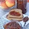 apple jam in a bowl with more on a bread and in a jar with apples in the background