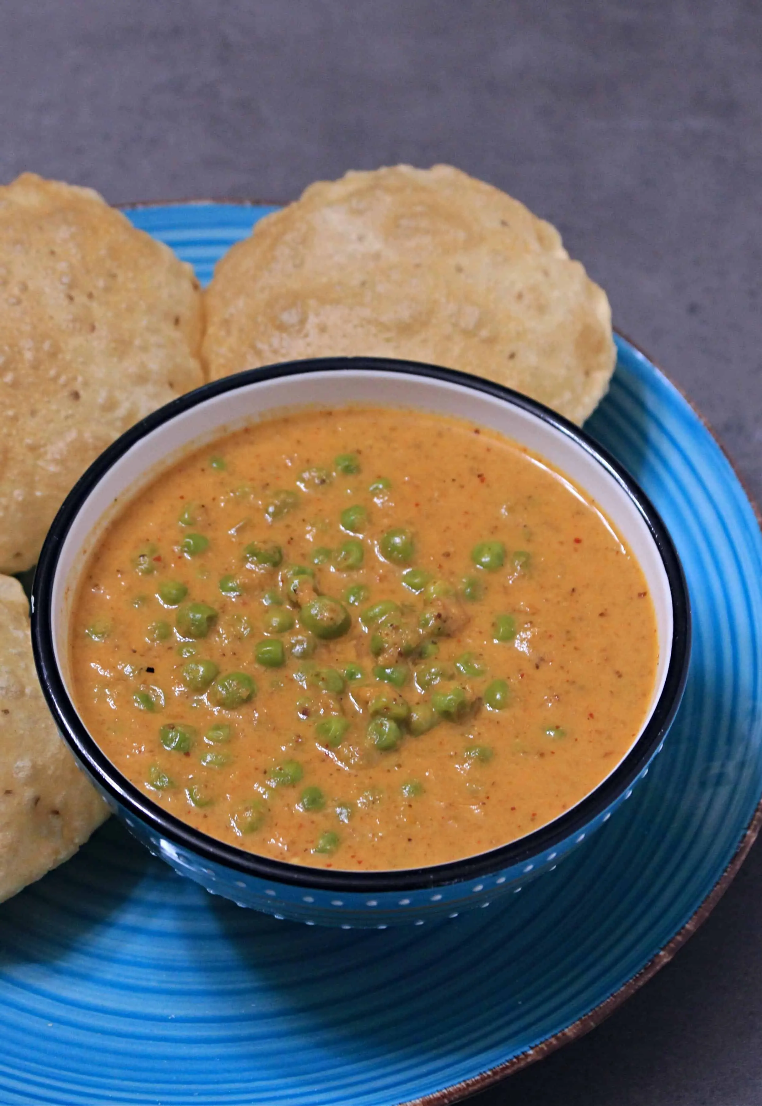 Kerala Style Peas Masala Curry served  with poori in background
