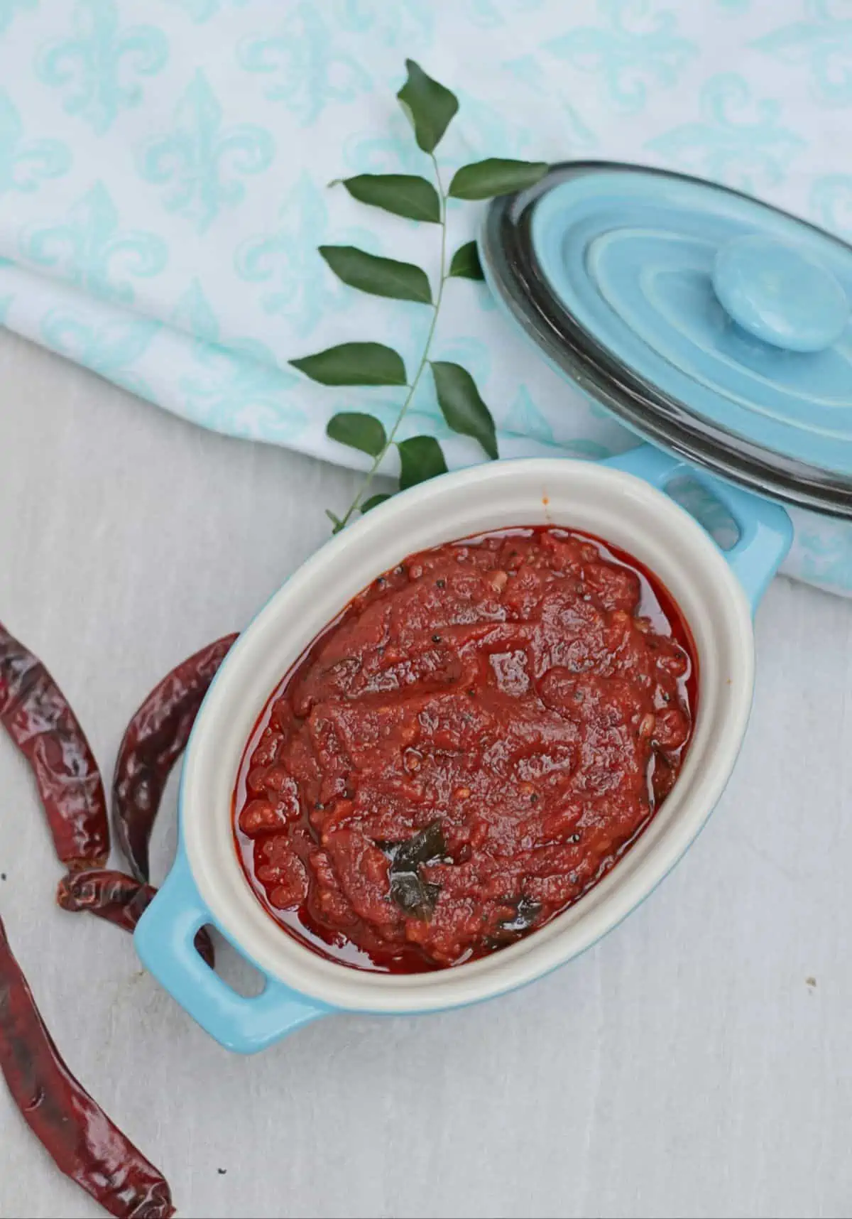 red chutney with chilies and curry leaves on side