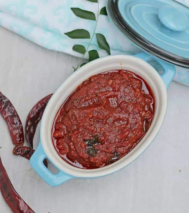 red chutney with chilies and curry leaves on side