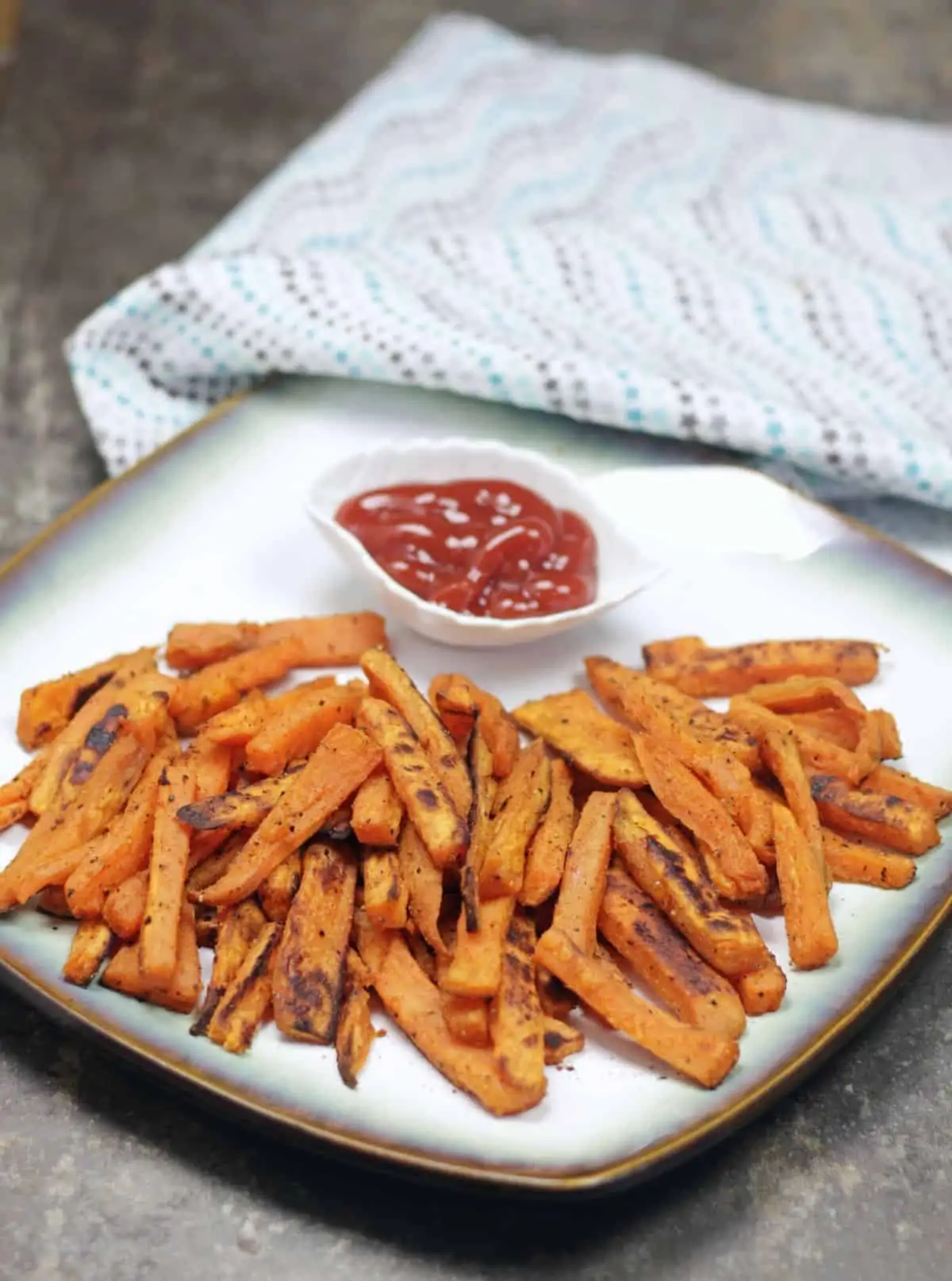 baked fires with ketchup in a plate.