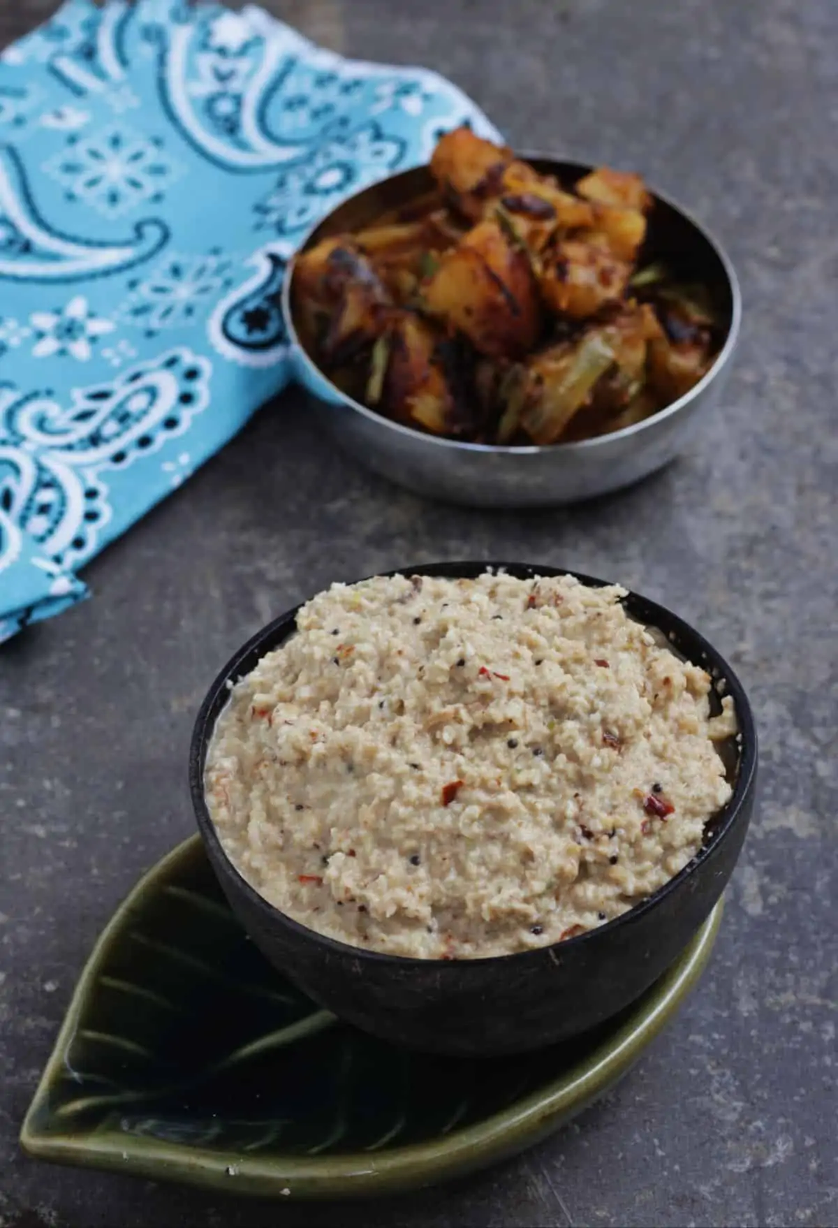 Thengai thuvayal in a brown bowl with potato fry in the background