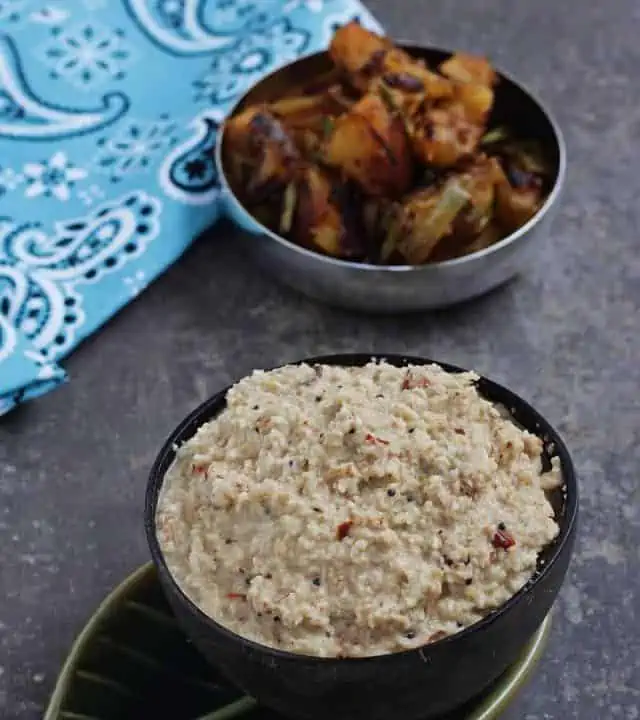 Thengai thuvayal in a brown bowl with potato fry in the background