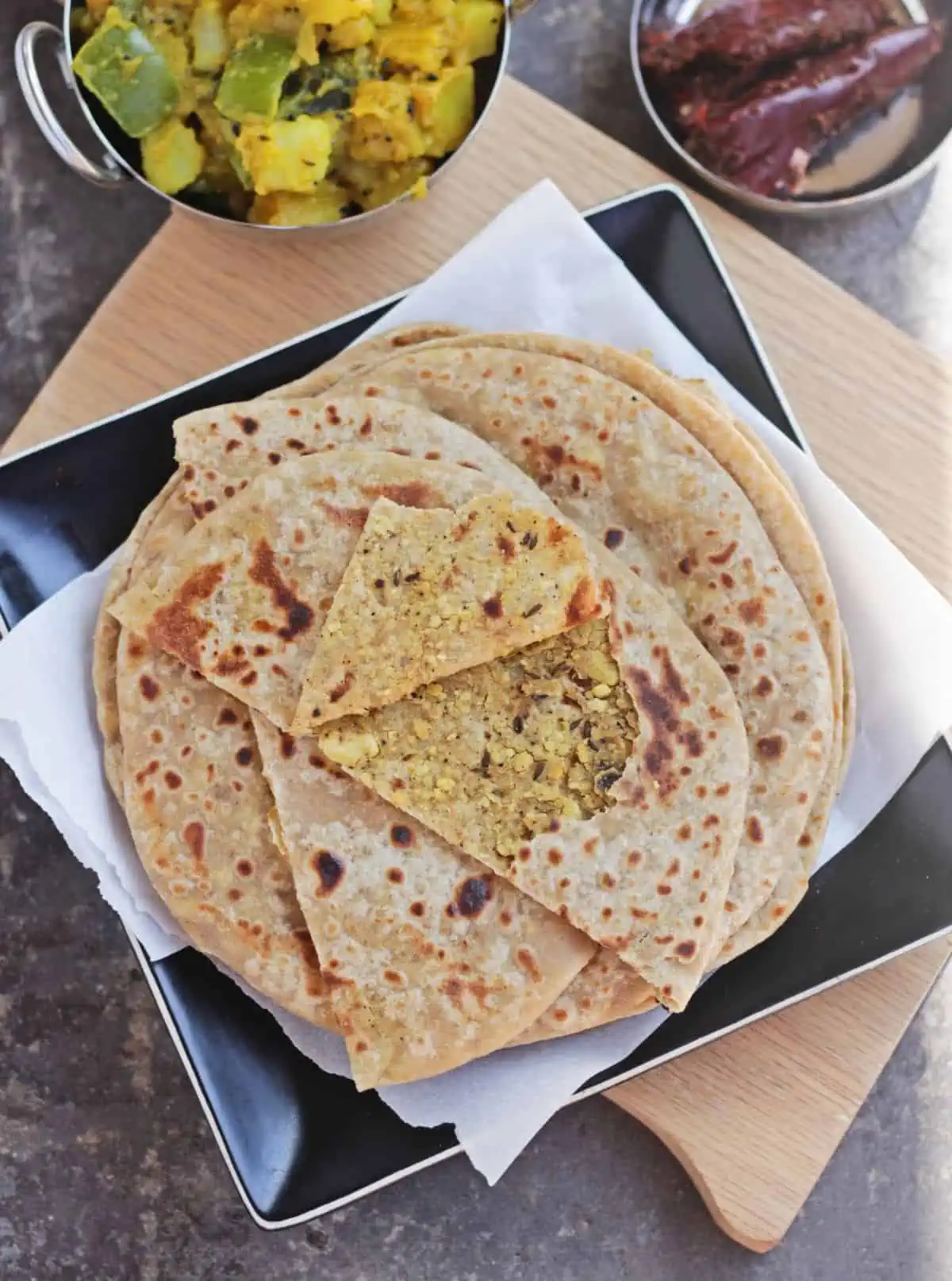 Layers of paratha with the top one showing a stuffed lentil filling. 