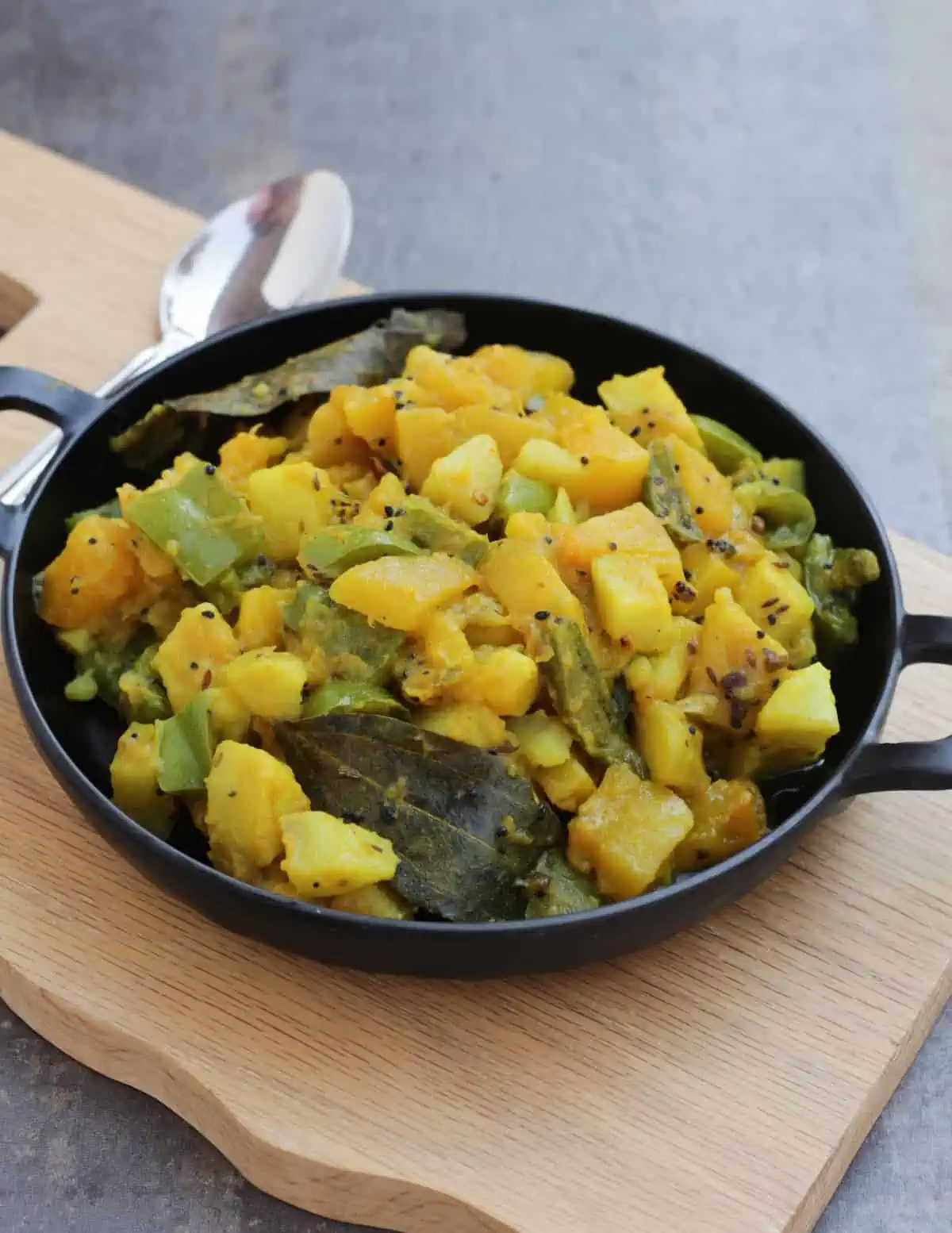 Mixed vegetable curry n a black bowl.