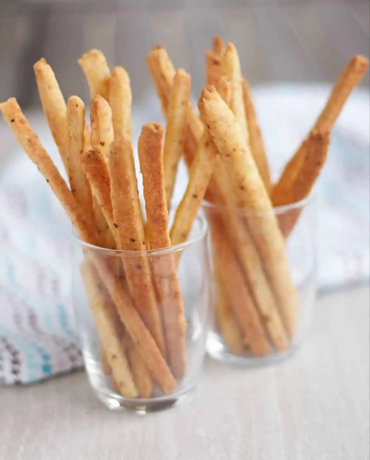 cheese straws in two clear glasses.