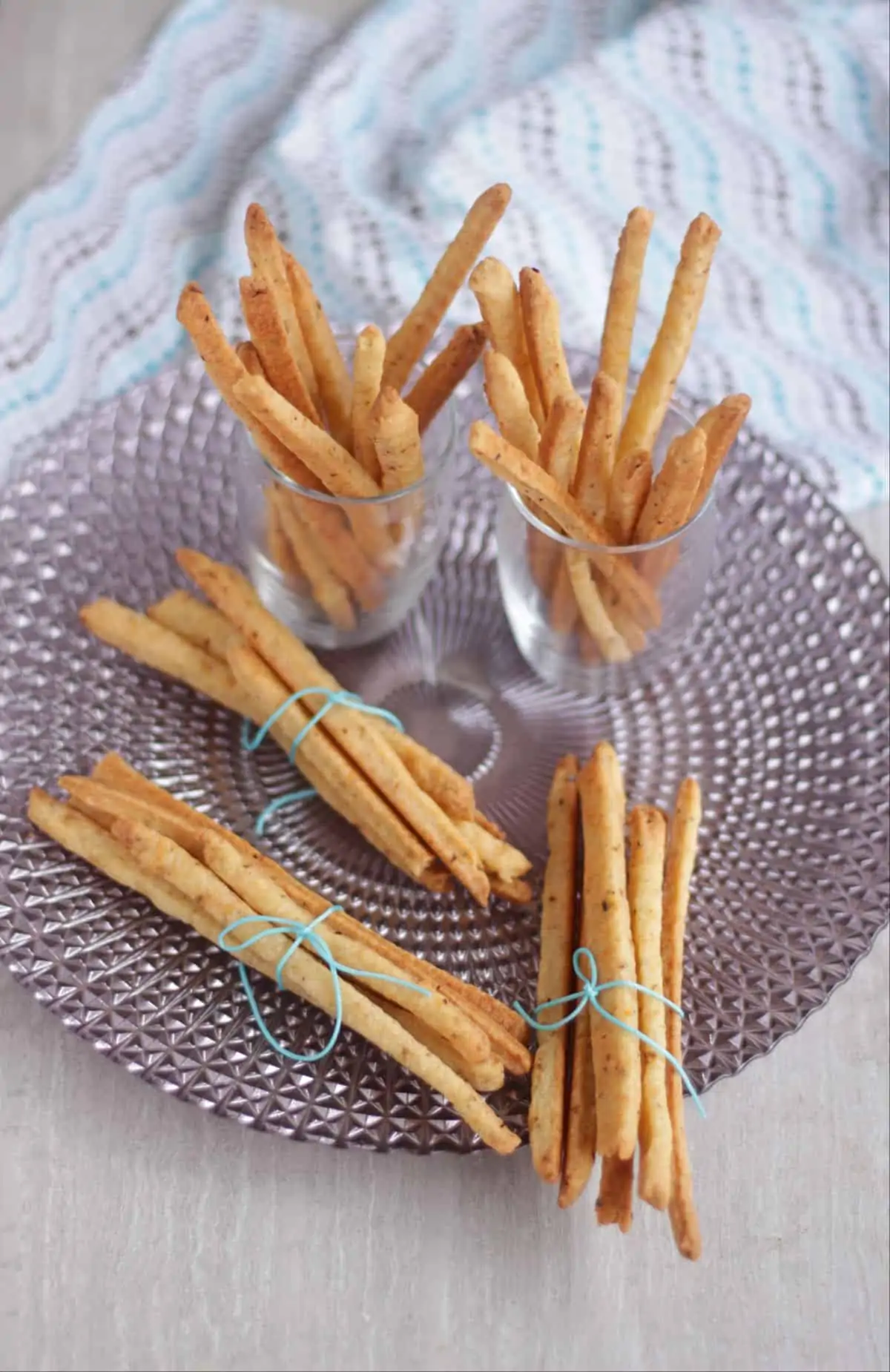 cheese straws in bundle in a plate and glass.