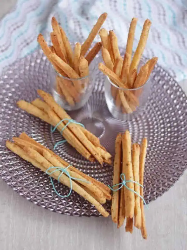 cheese straws in bundle in a plate and glass.