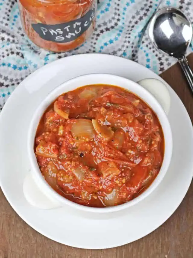 Roasted tomato pasta sauce in a white bowl and a mason jar