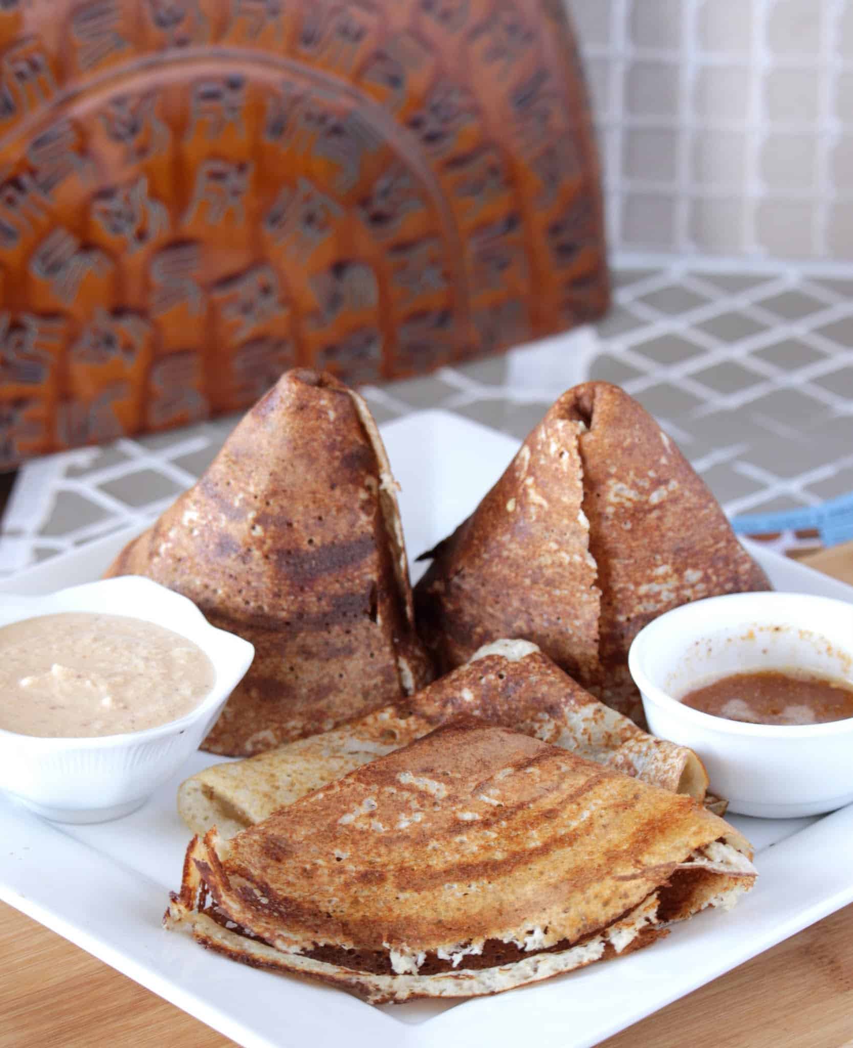 Quinoa dosai made as a cone with chutney and sambhar