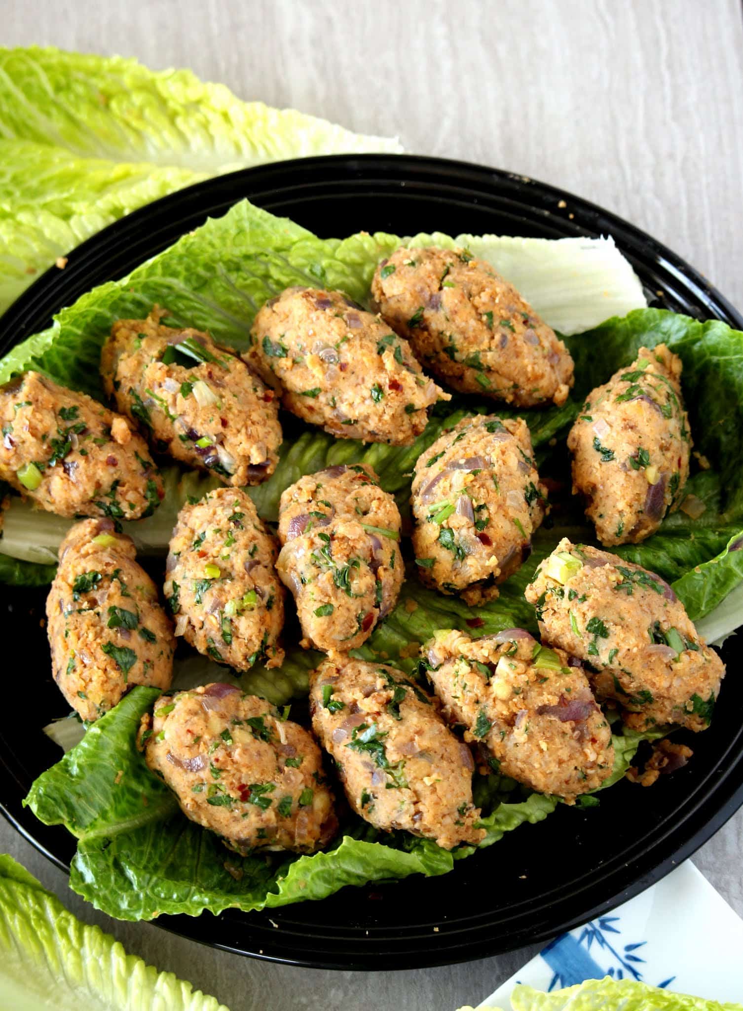 Bulgur Koftesi ober a bed of lettuce in a black plate