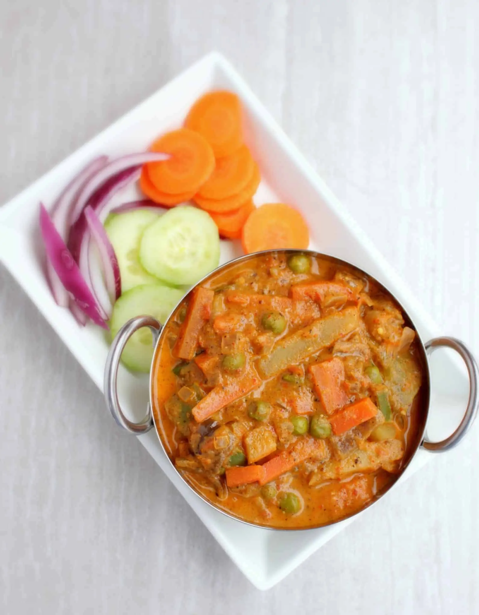 Kadai Vegetable Gravy with cucumber, Onion and carrot on the side - top view