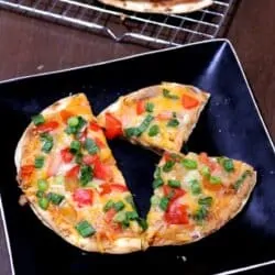 Mexican pizza with cheese, tomatoes and green onions