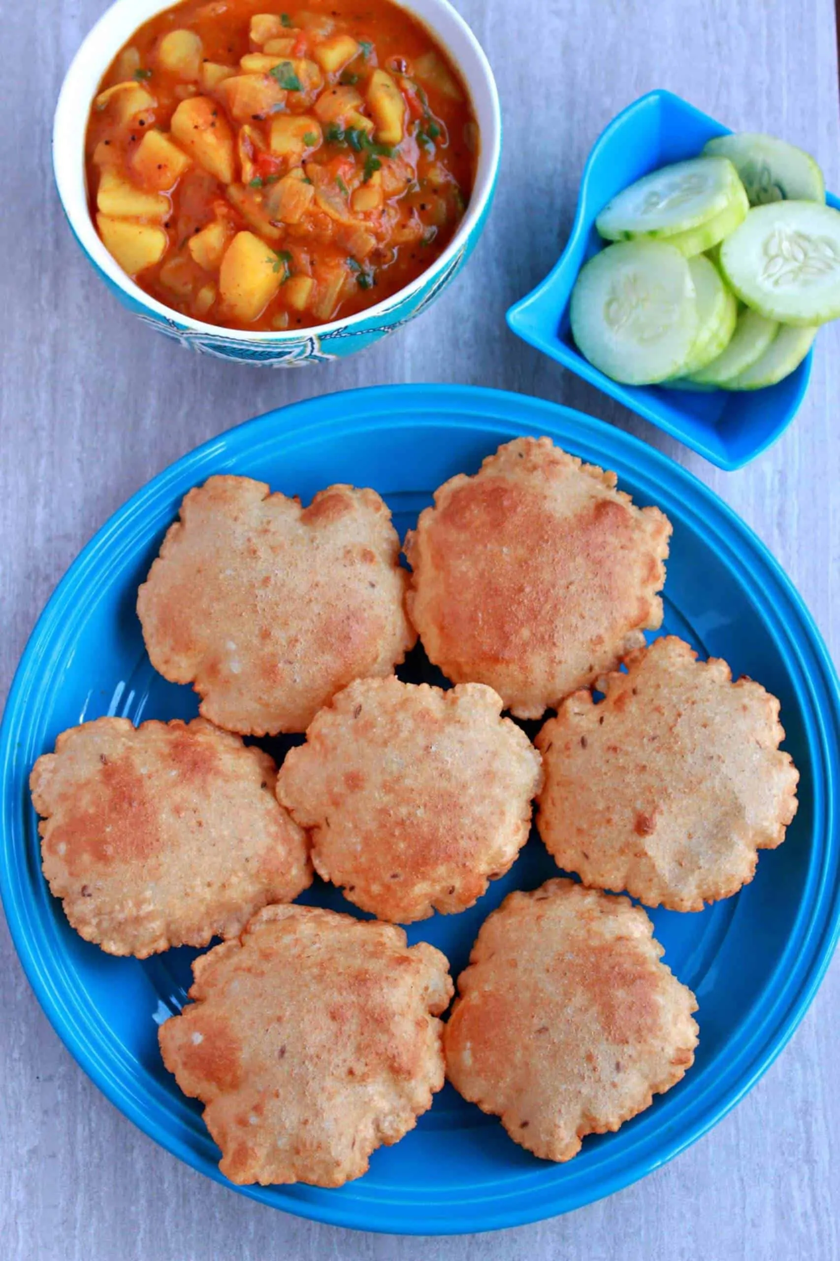 Rajgira Aloo Poori served with cucumber slice.