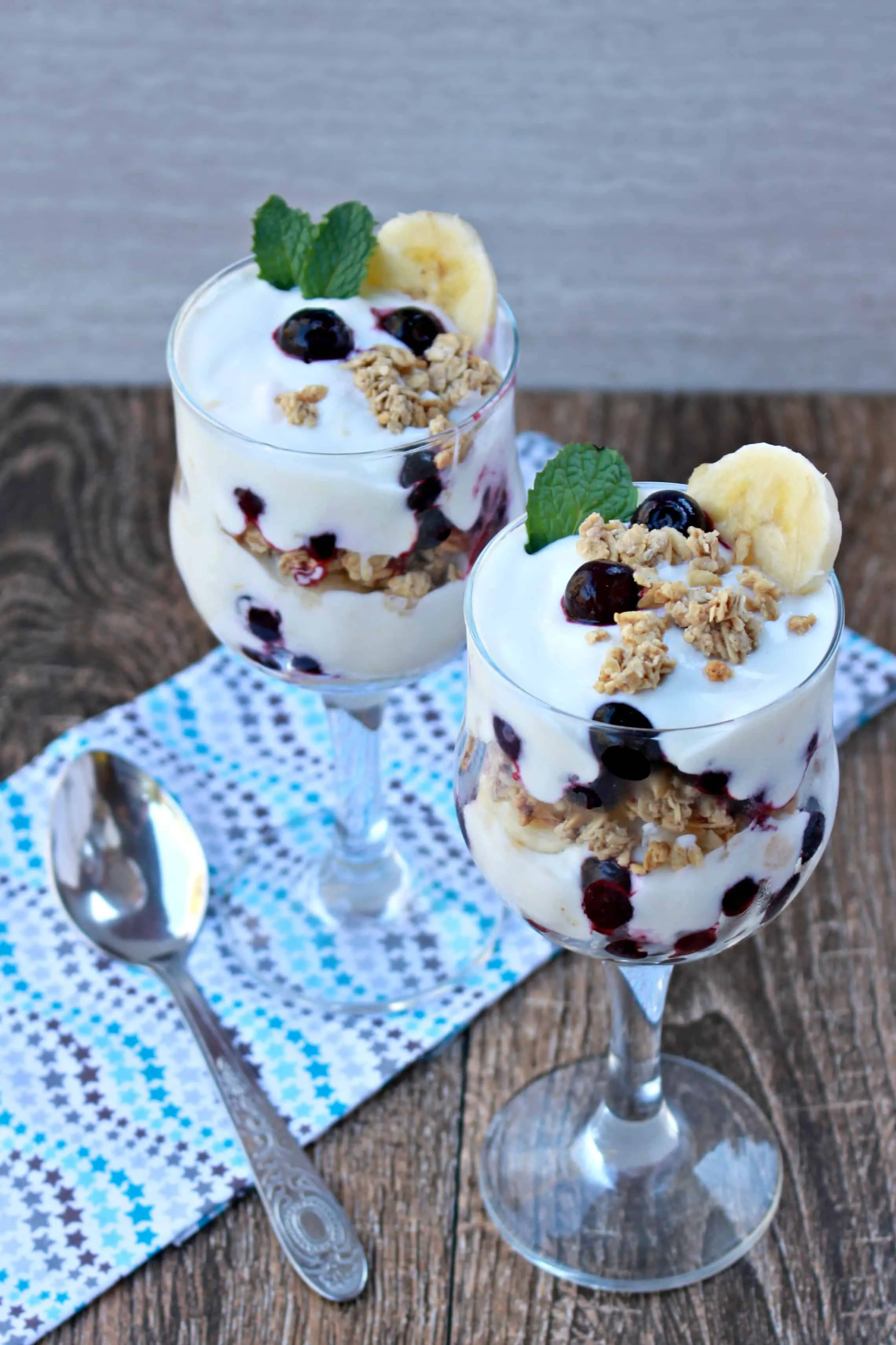 Yogurt Blueberry Banana Granola Parfait in two glasses