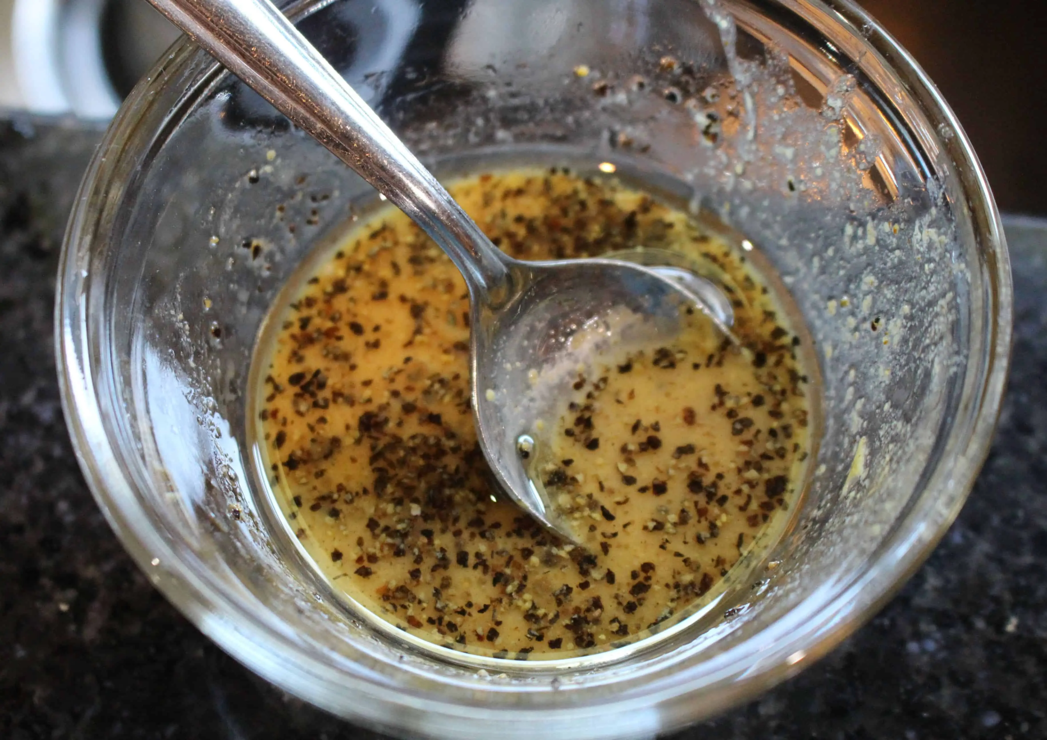 Mixing the dressing in a bowl.