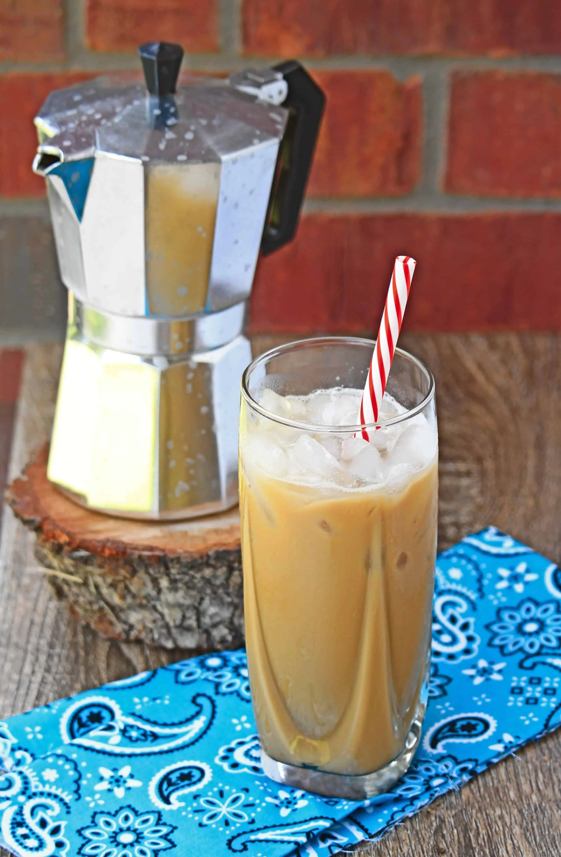 Ca Phe Sua Da in a tall glass cup with perculator in the background