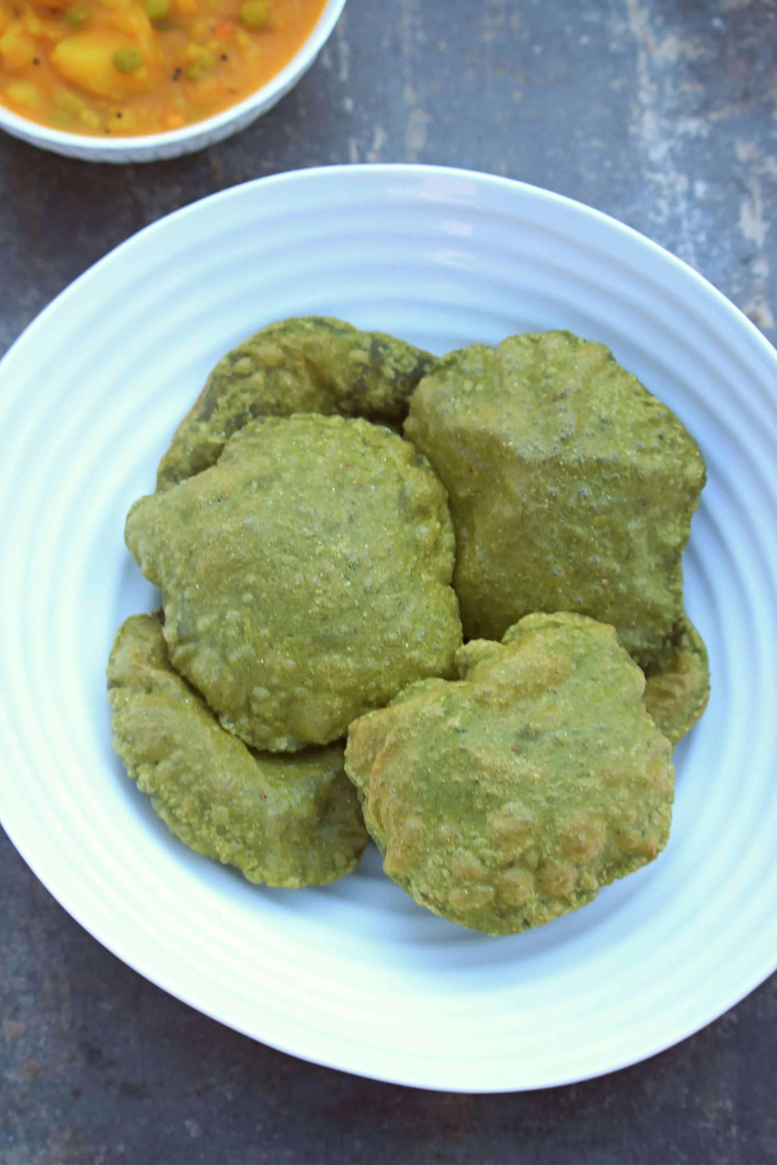 spinach poori in a white dish