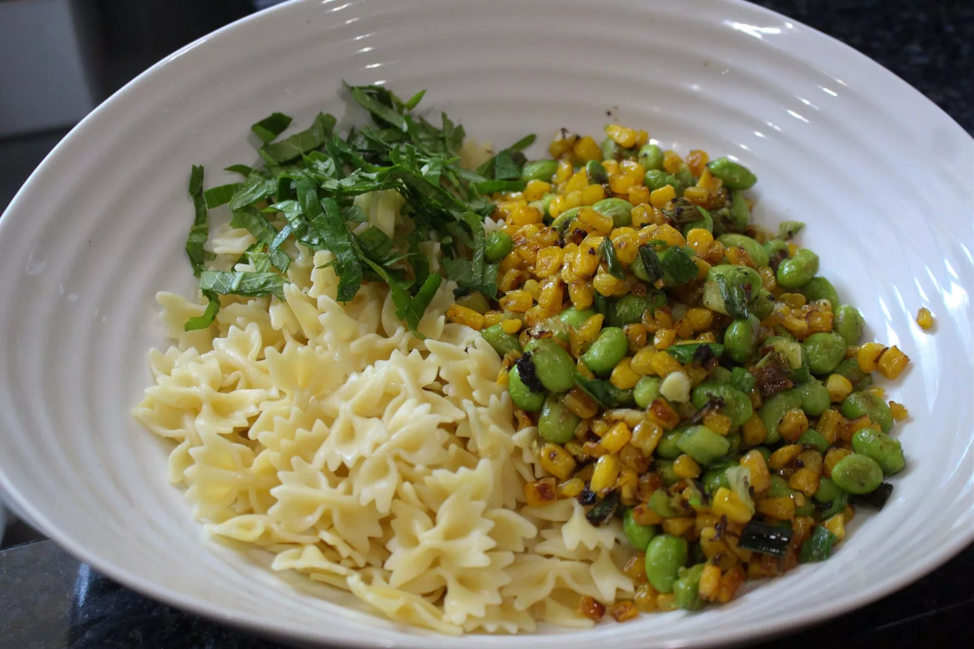 Combining ingredients for pasta salad