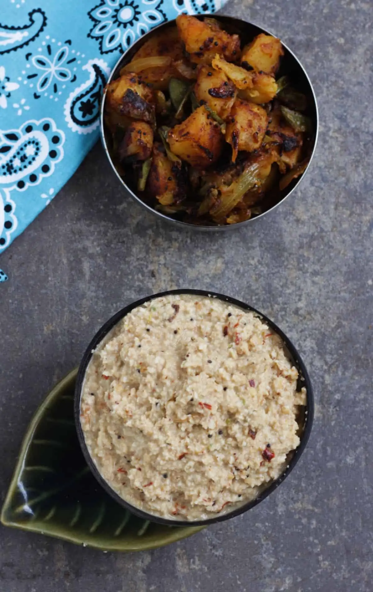 thengai thuvayal in a bowl with potato curry in the background