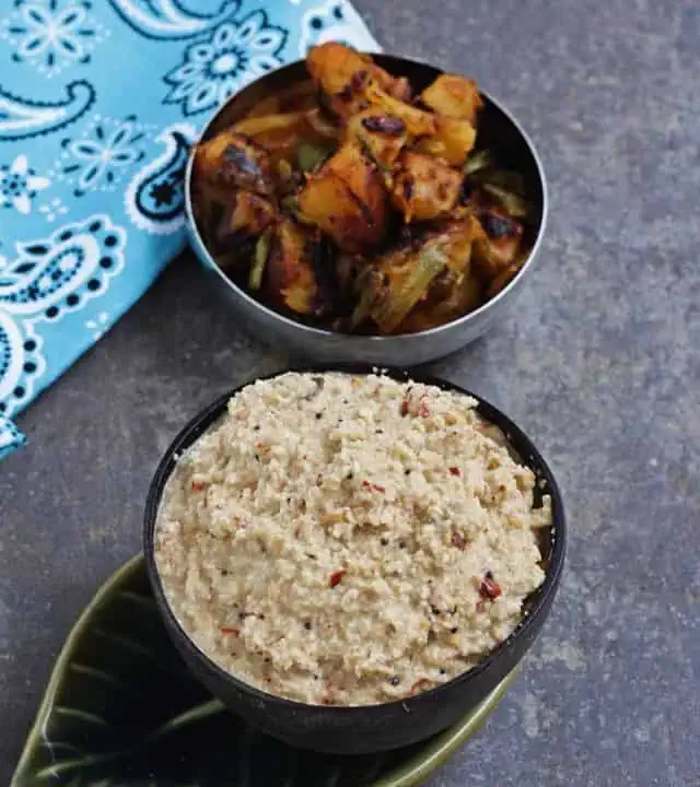 fried coconut chutney in a brown bowl with potato curry on the side