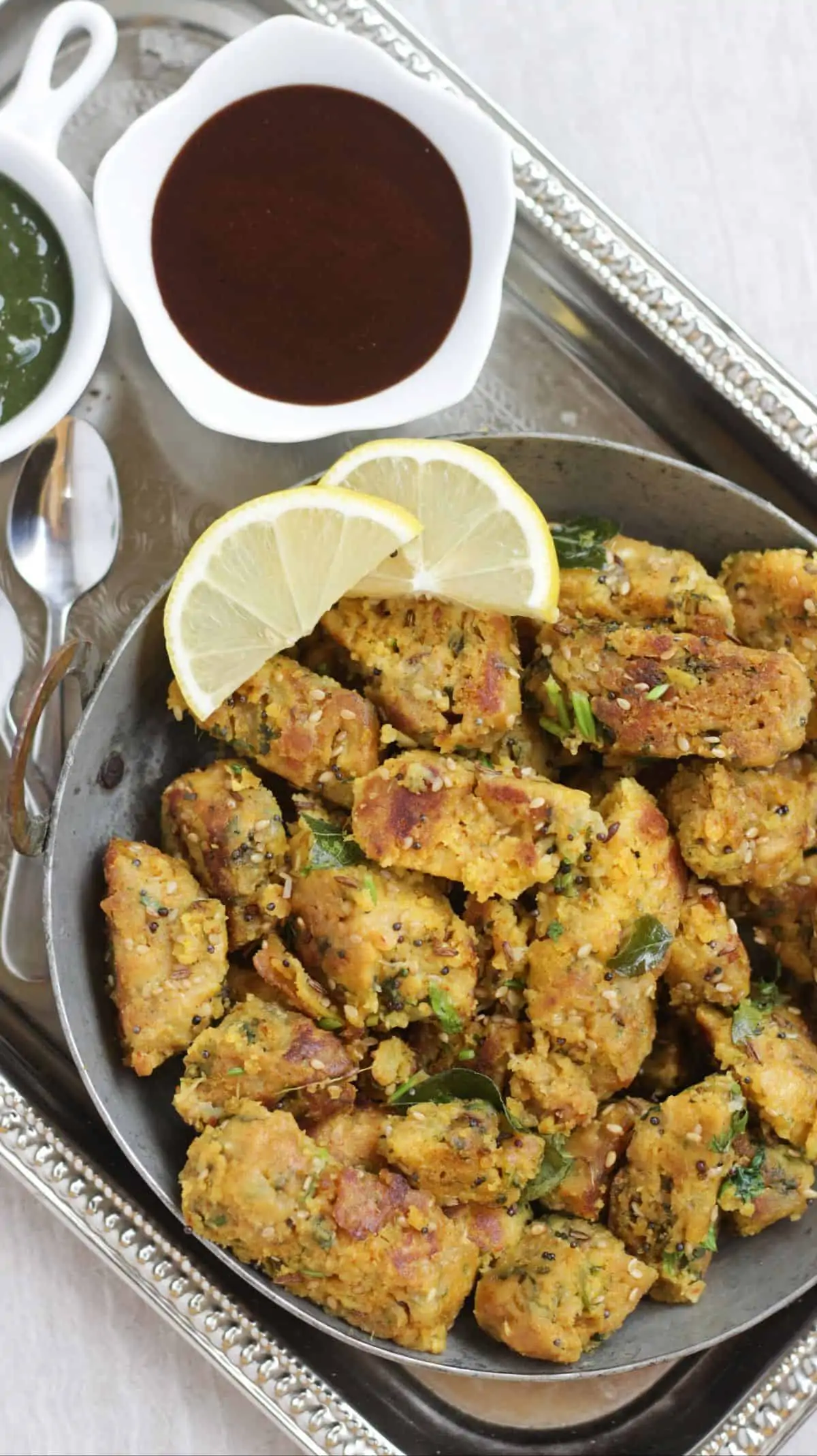 lauki muthiya in a plate with lemon pieces as garnish