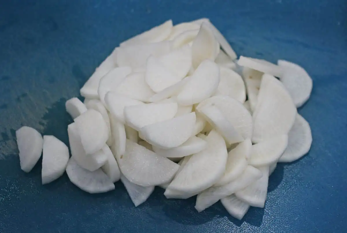 Sliced radish on a blue cutting board.