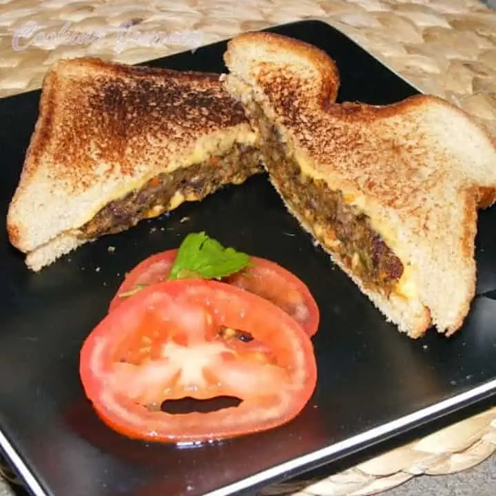 Bulgur Black Bean Vegetable Patties in bread on a black plate - Featured Image