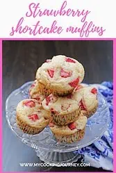 Top view of stacked strawberry shortcake muffins with text.