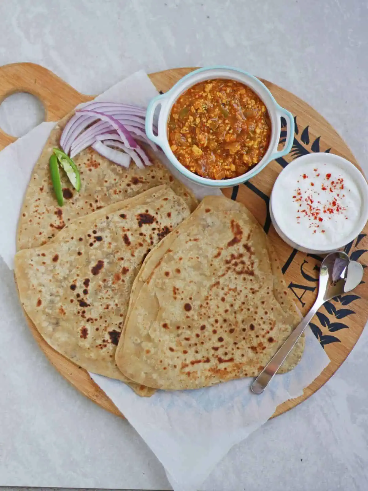 Top view of Carom seeds paratha in a plate with side.