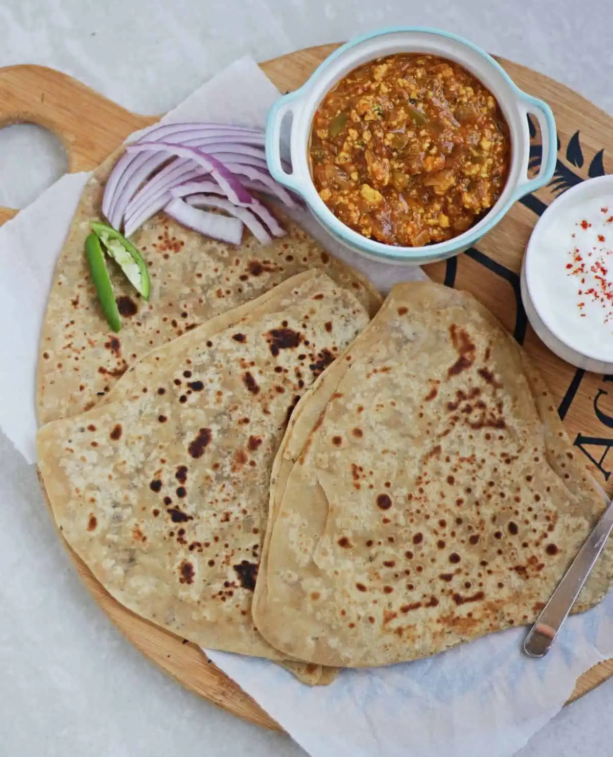 Ajwain paratha with subzi and yogurt and salad. on a plate. 