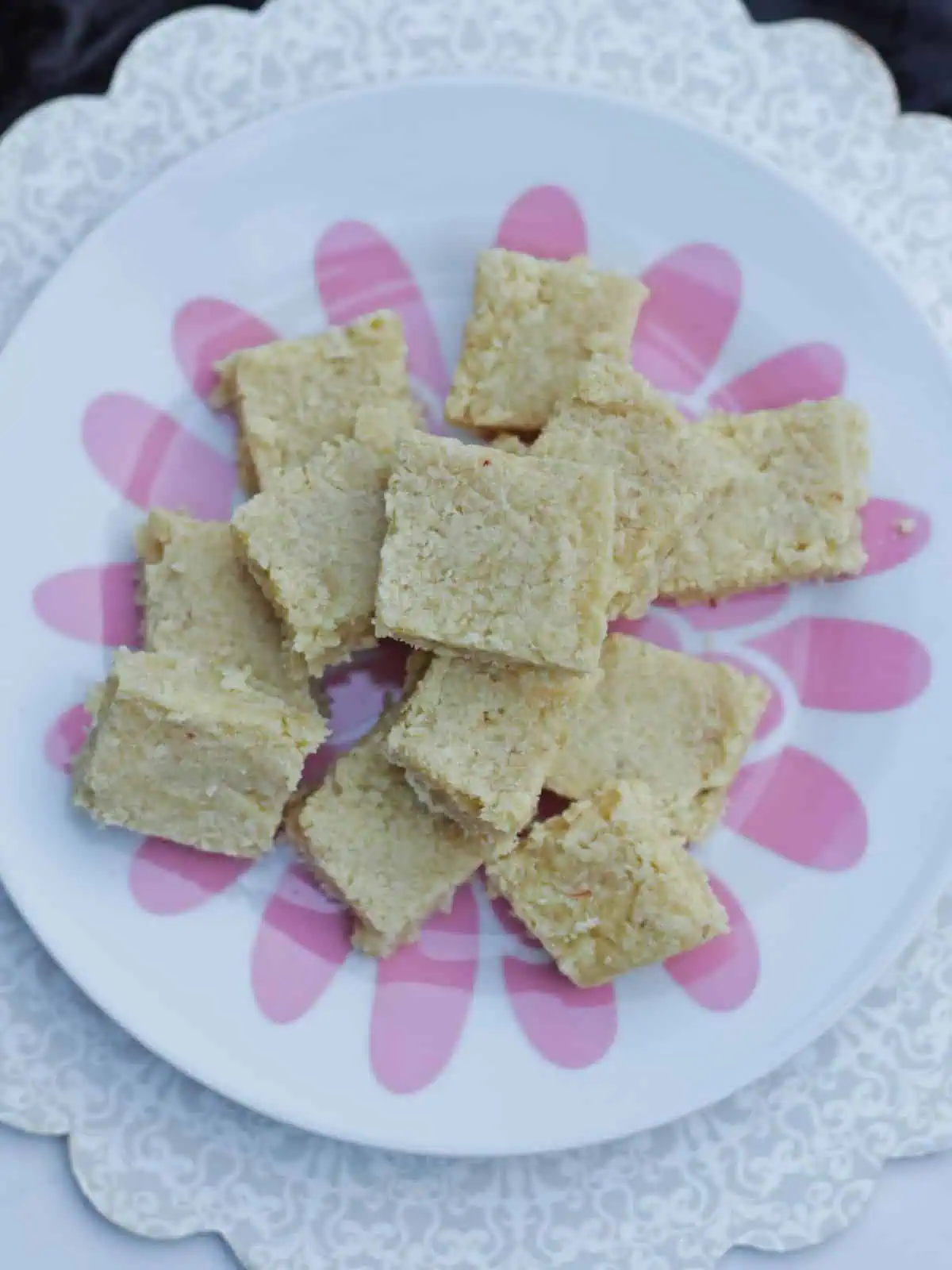 coconut and almond flour burfi stacked in a plate.