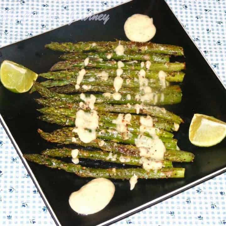 Roasted Asparagus with creamy dipping sauce in a black plate - Feature Image